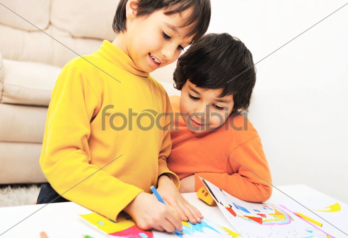 two adorable happy children drawing with crayons