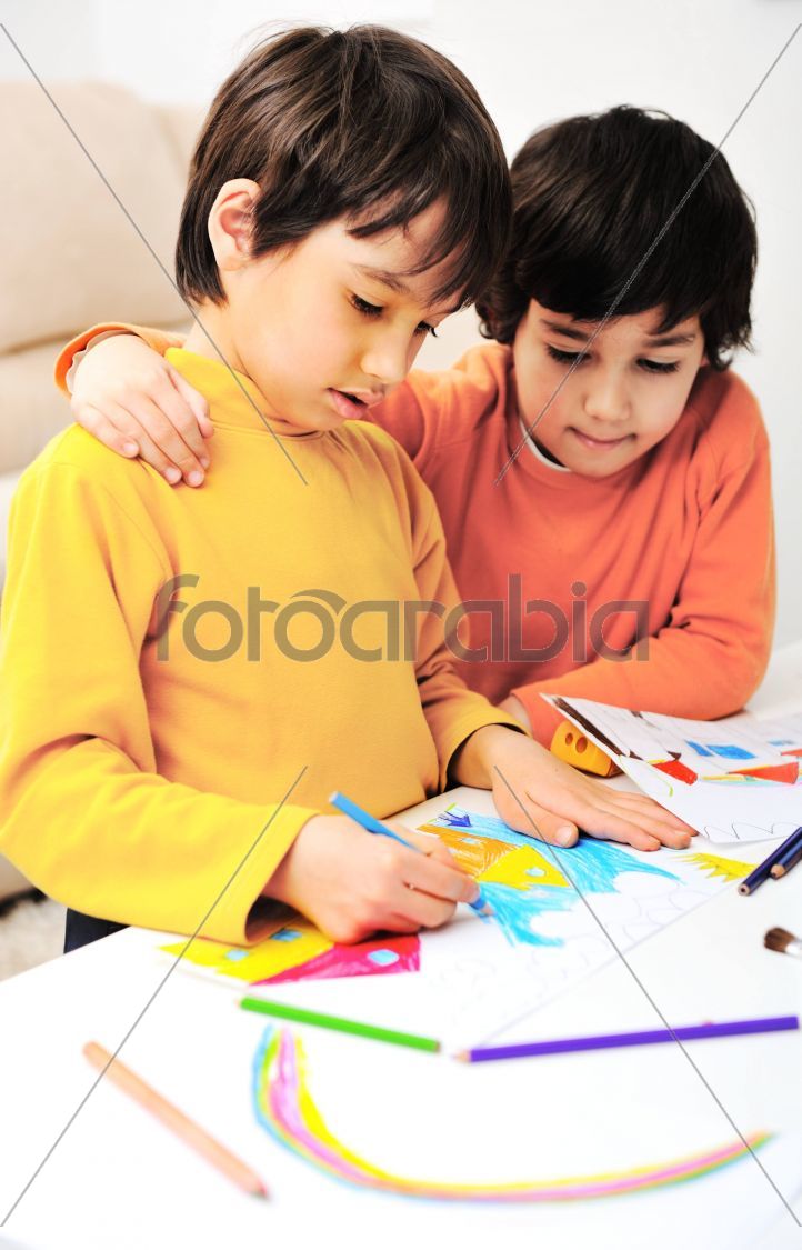 two adorable happy children drawing with crayons