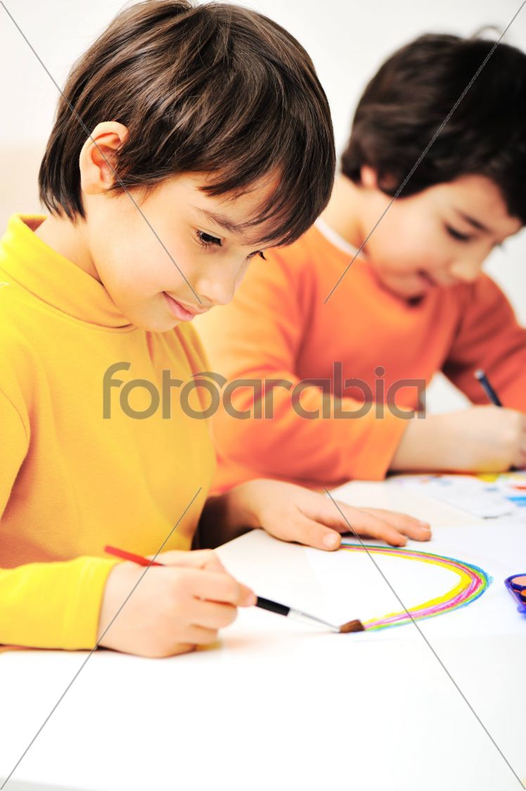 two adorable happy children drawing with crayons