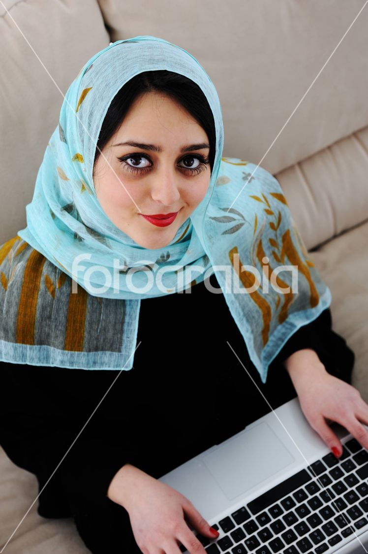 Asian Arabic young with laptop on sofa