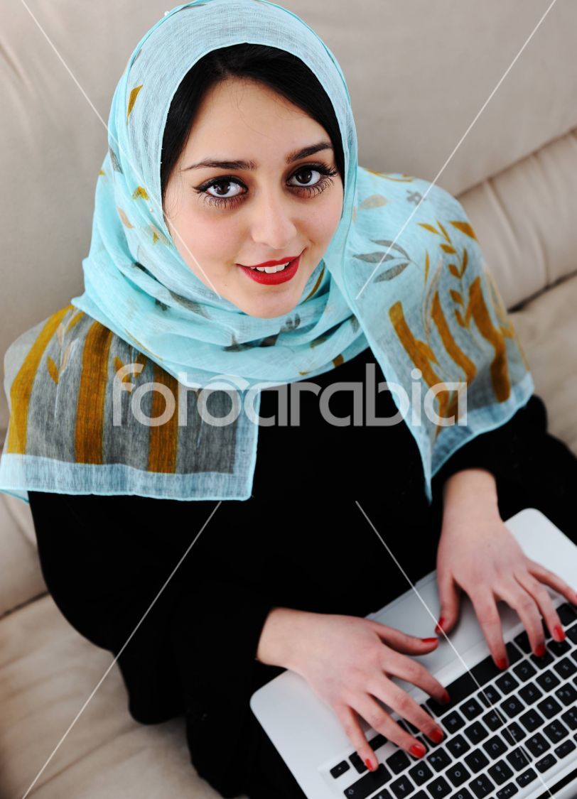 Asian Arabic young with laptop on sofa