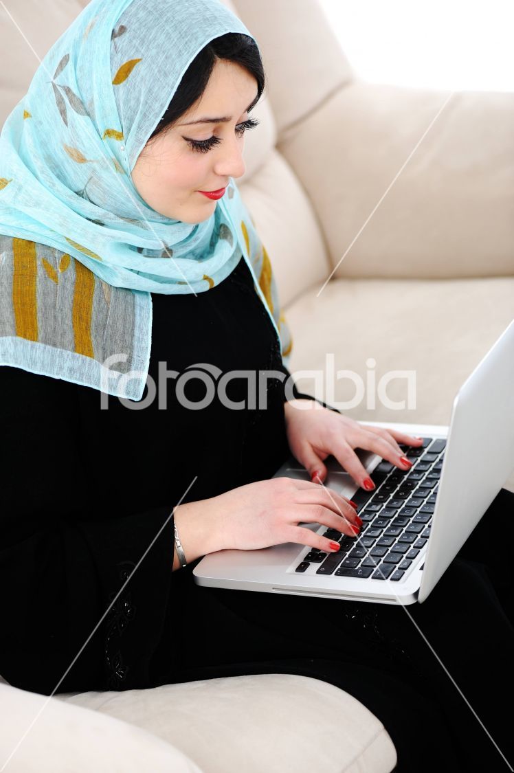 Asian Arabic young with laptop on sofa