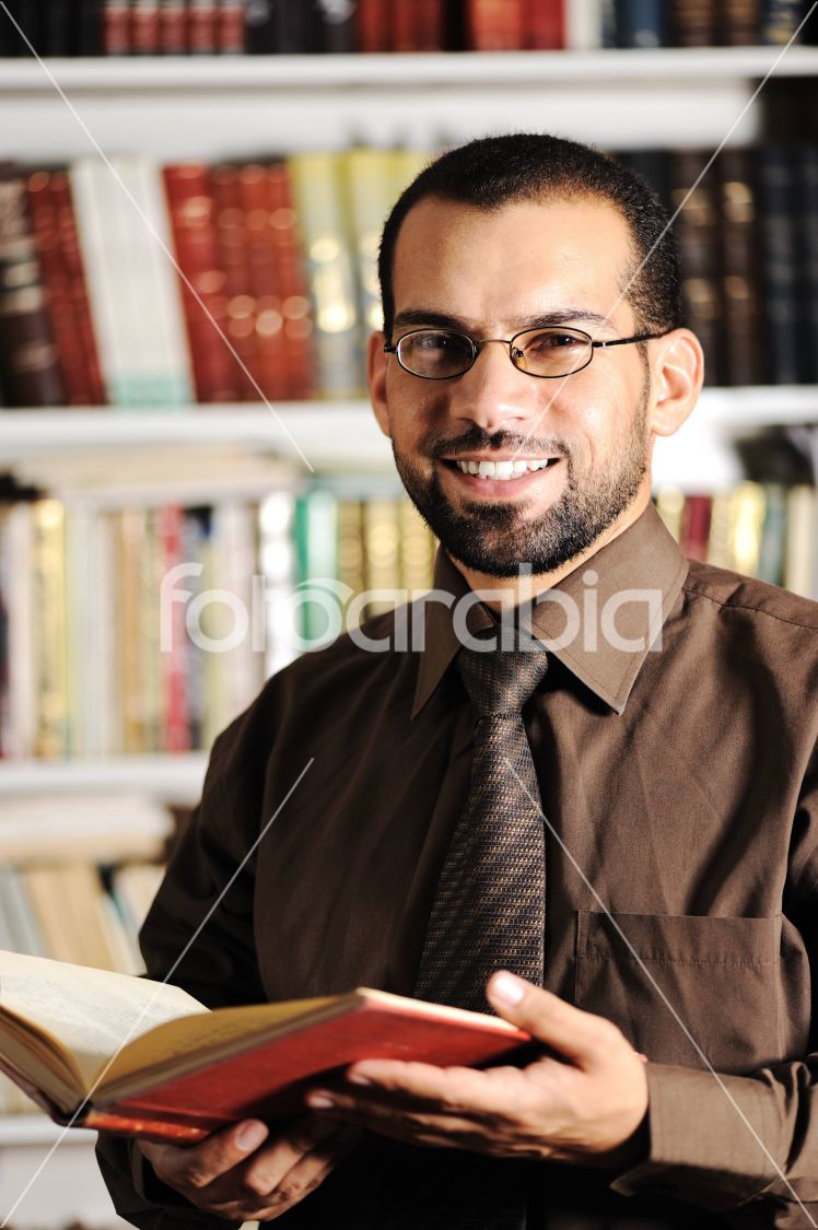 Young man reading book in library