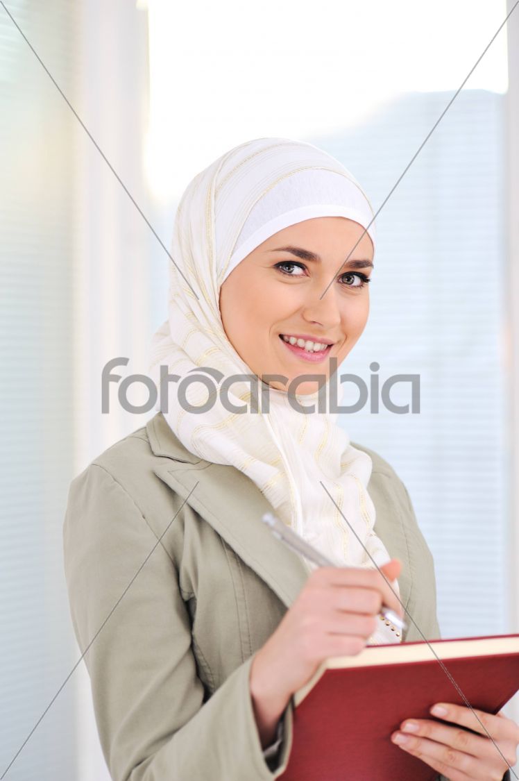 Muslim Caucasian female student with notebook and pen