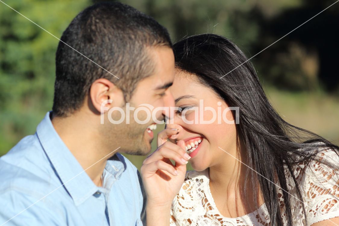 Arab casual couple man and woman flirting and laughing happy in a park