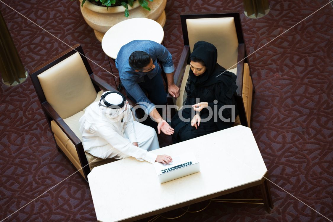 Three Qatari people in a meeting