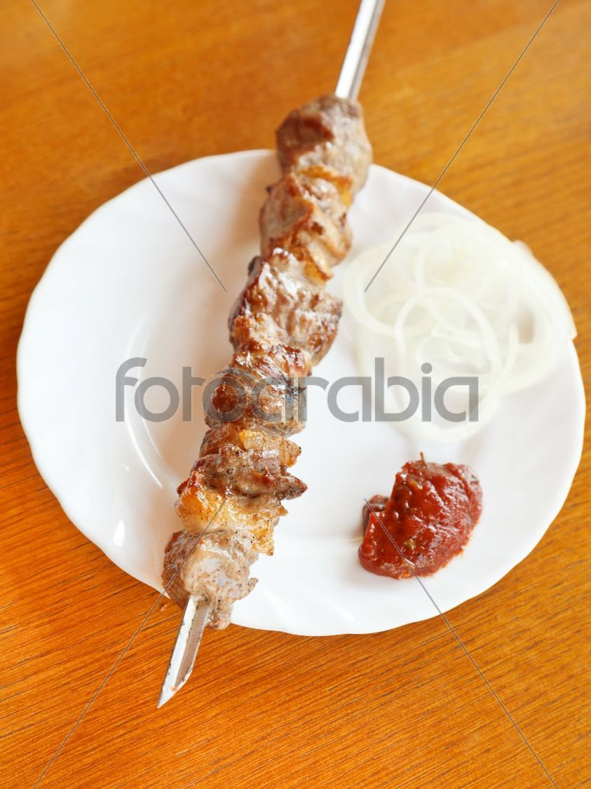 skewer of lamb shish kebab on white plate