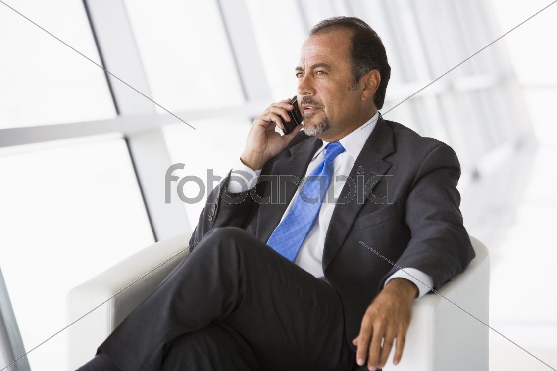 Businessman talking on mobile phone in lobby