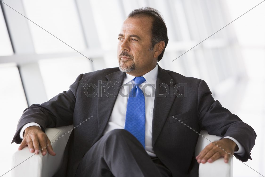 Businessman sitting in chair in lobby