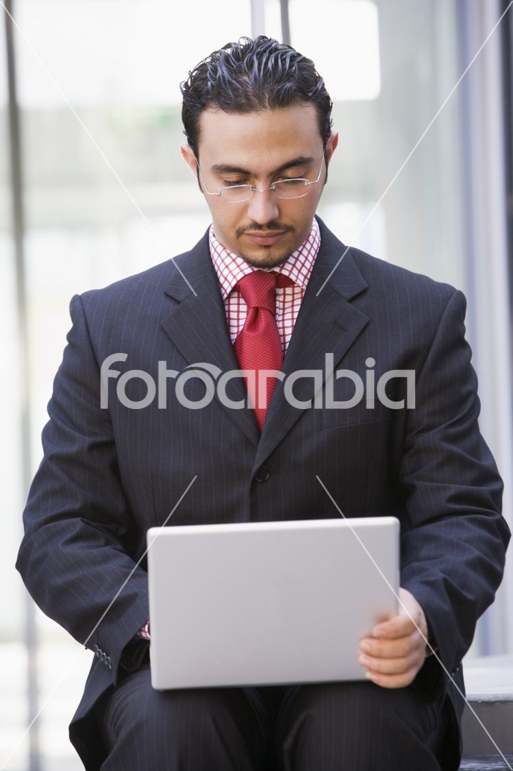 Businessman using laptop outside
