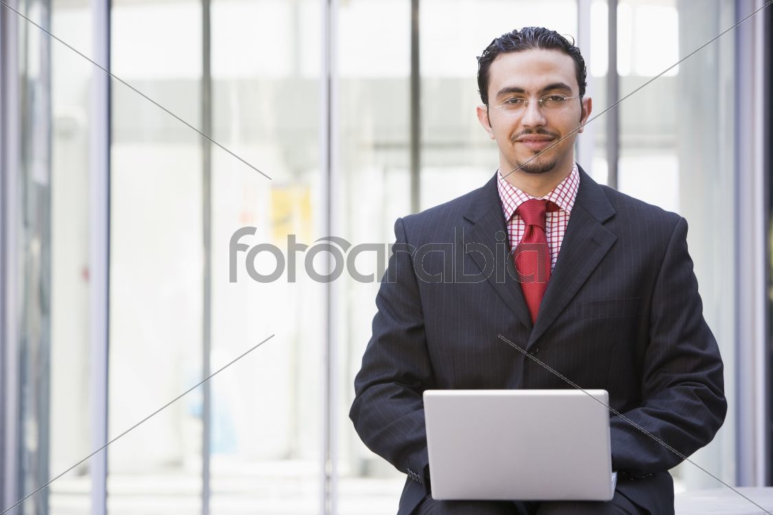 Businessman using laptop outside