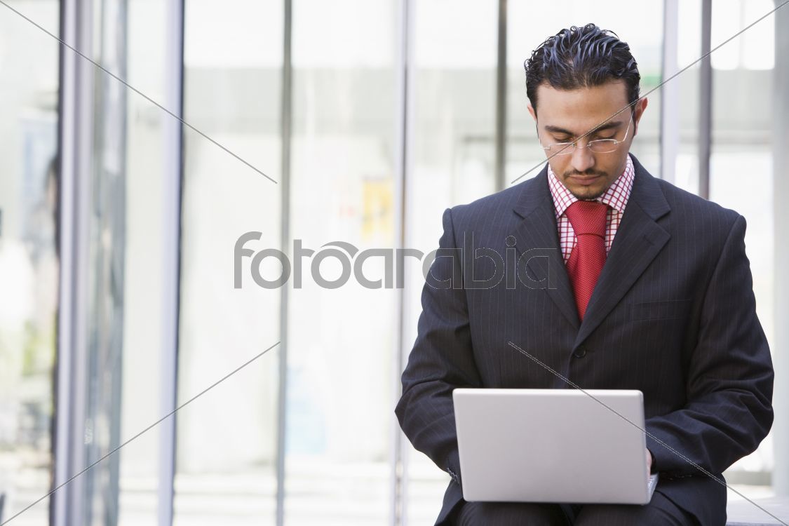 Businessman using laptop outside