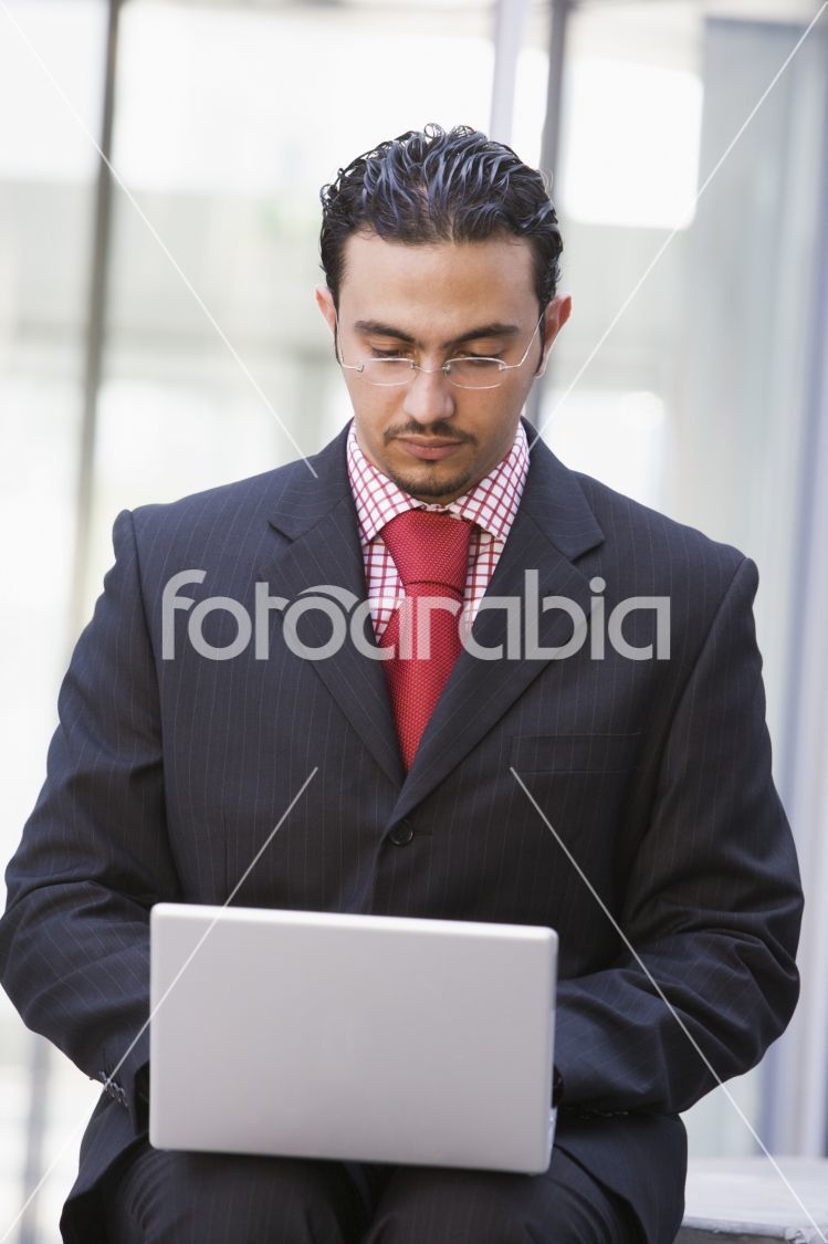 Businessman using laptop outside
