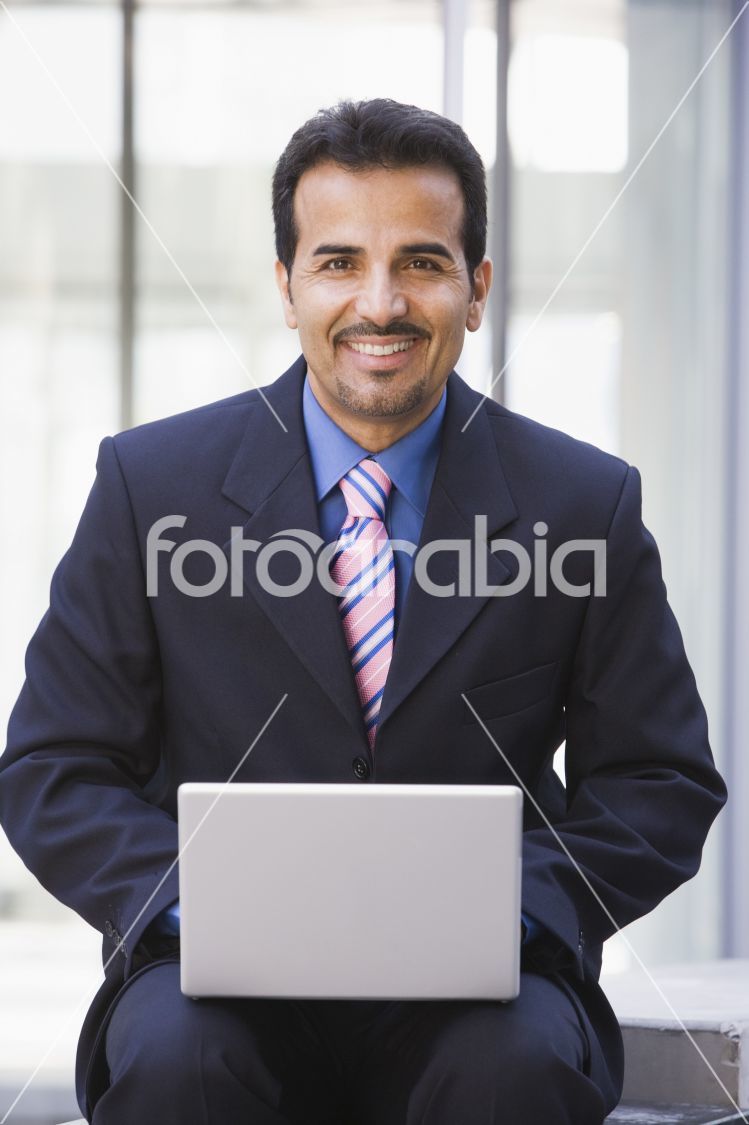 Businessman using laptop computer outside