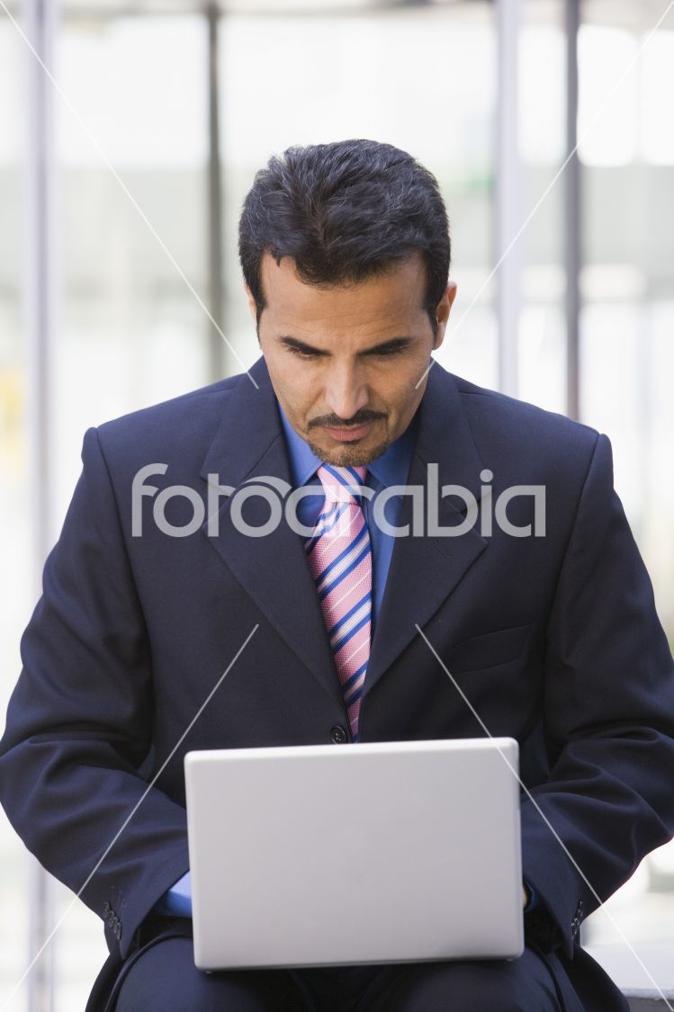 Businessman using laptop computer outside