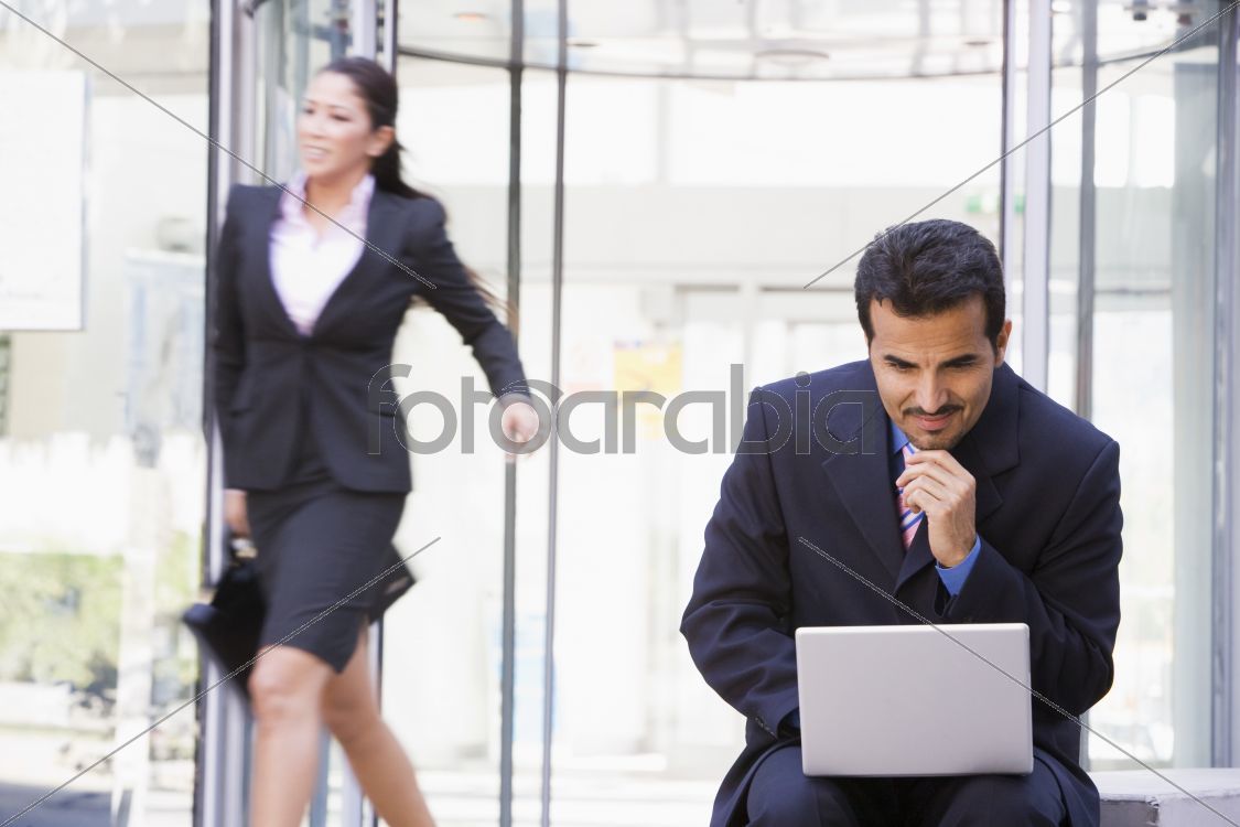 Businessman working at laptop outside