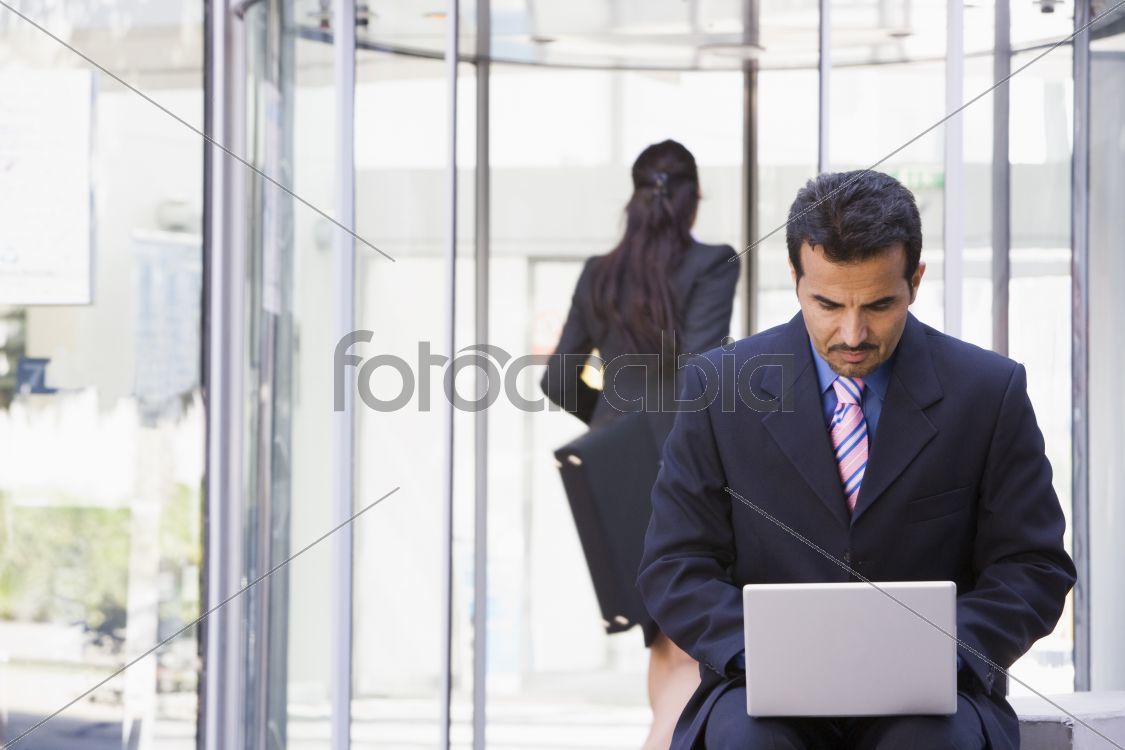 Businessman using laptop computer outside