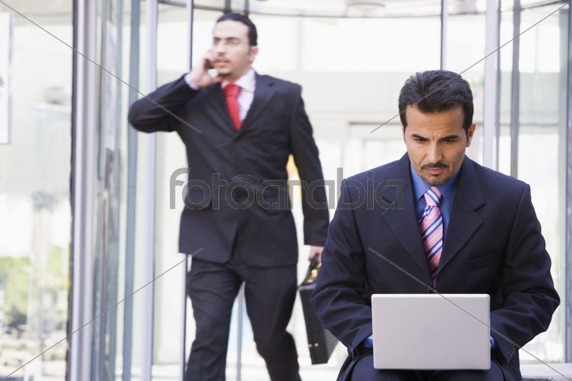 Businessman working at laptop outside