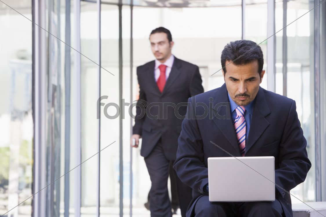 Businessman using laptop outside