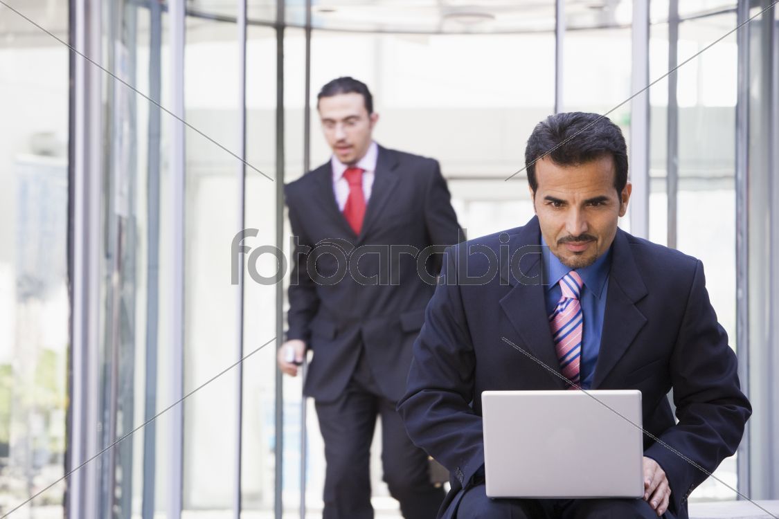 Businessman working at laptop outside