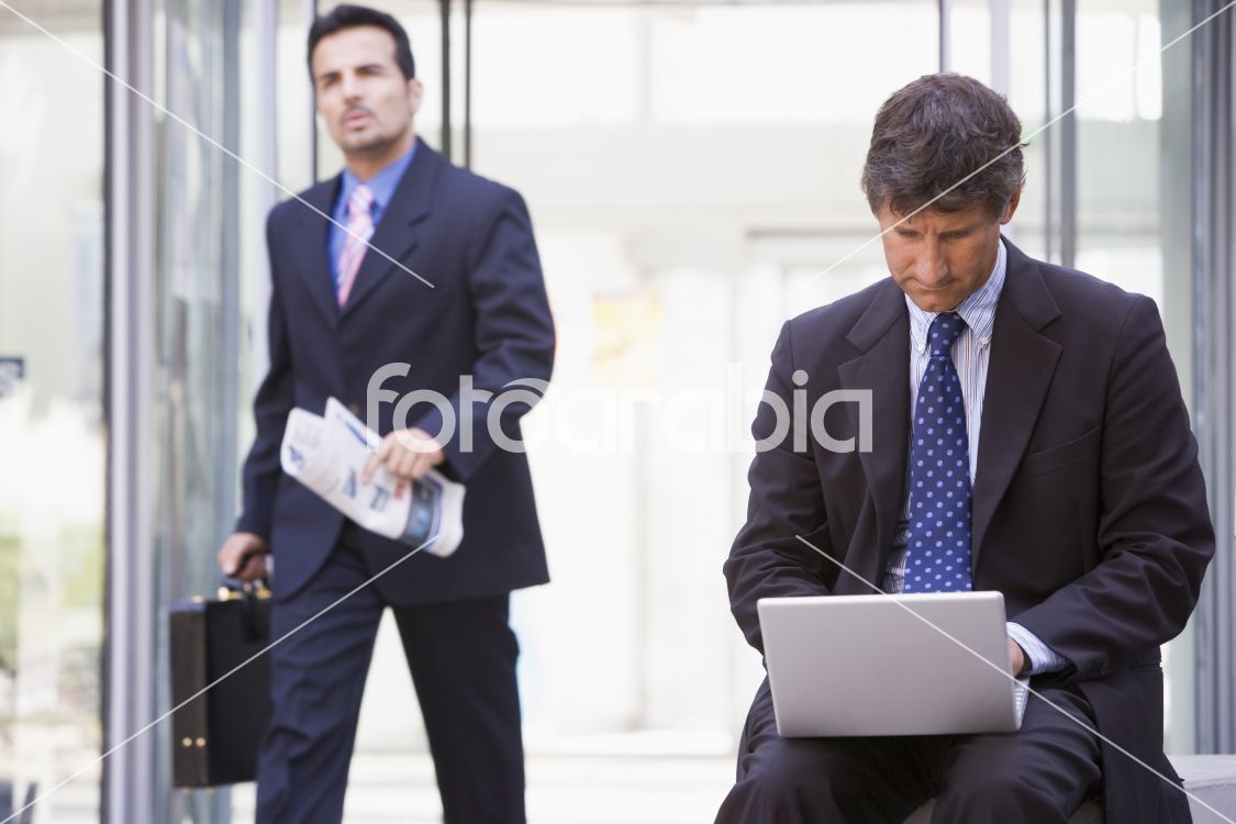 Businessman working at laptop outside