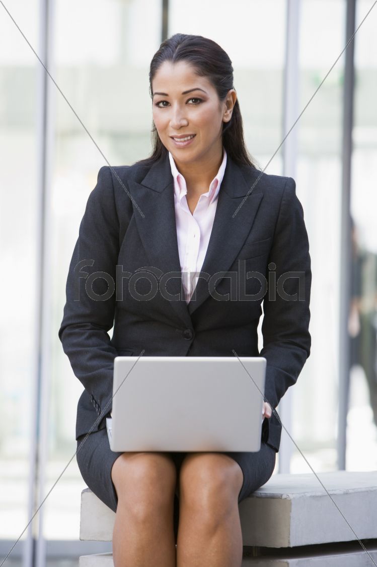 Businesswoman using laptop computer outside
