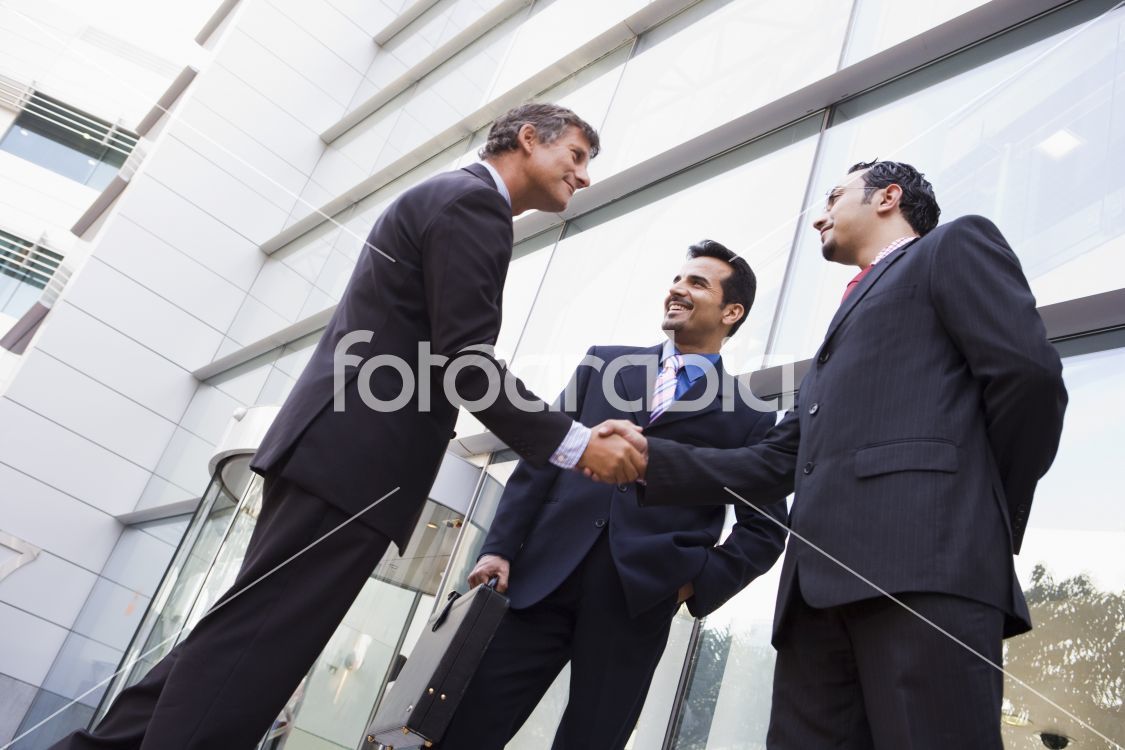Business people shaking hands outside office