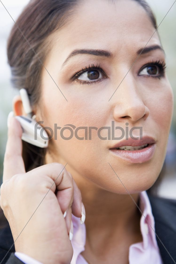 Woman using bluetooth earpiece