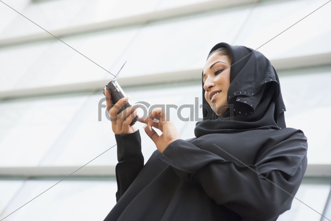 A Middle Eastern businesswoman using a PDA