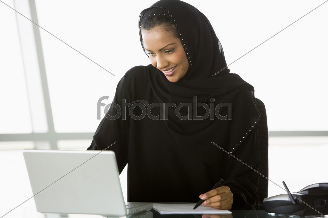 A Middle Eastern businesswoman using a laptop
