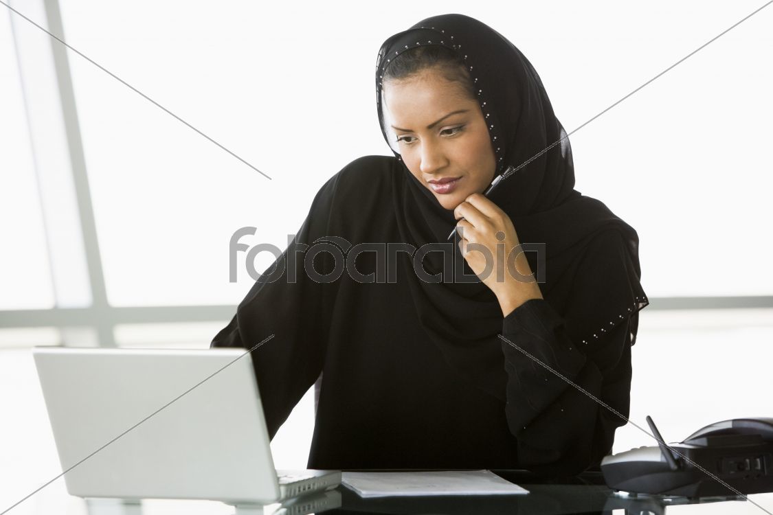 A Middle Eastern businesswoman using a laptop