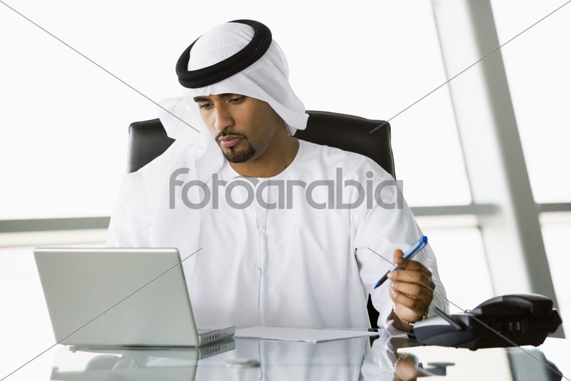 A Middle Eastern businessman using a laptop