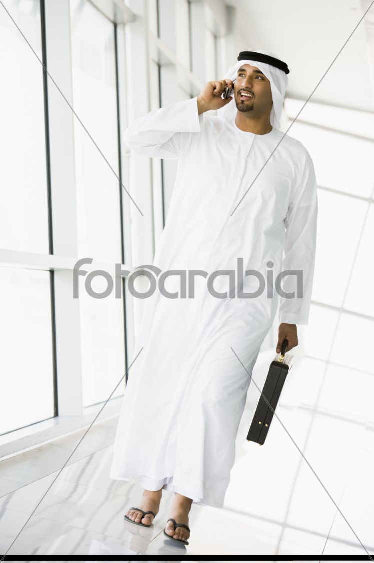 A Middle Eastern businessman walking in a corridor