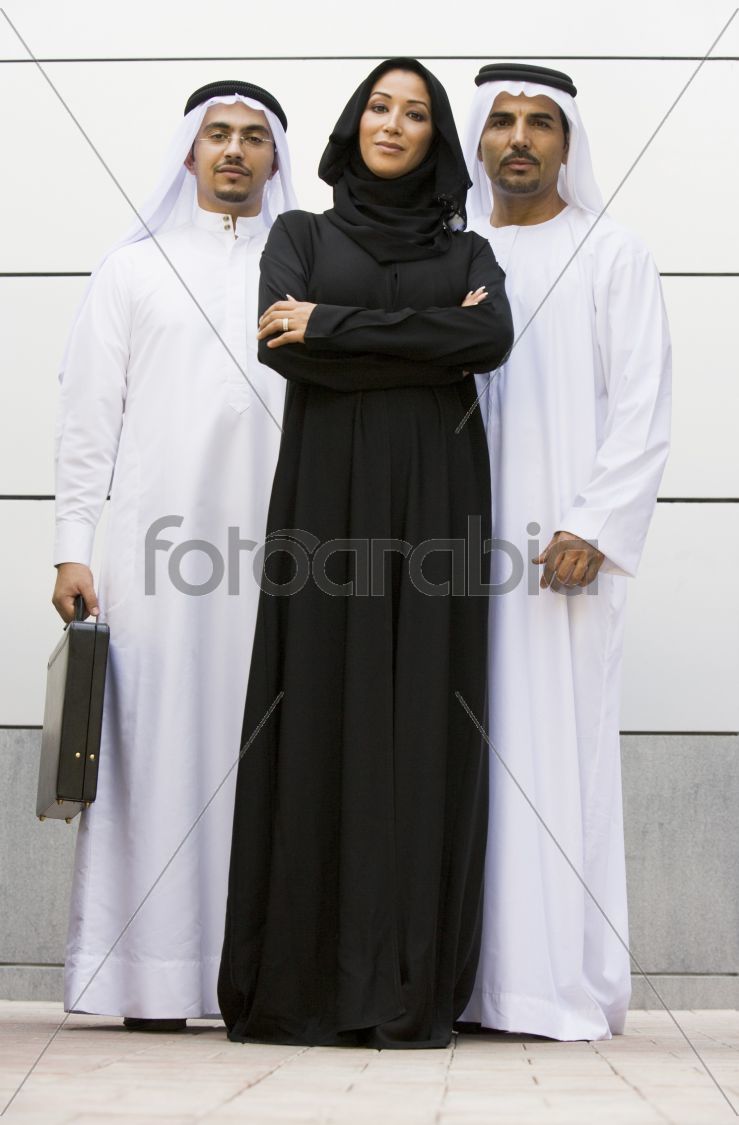 Two Middle Eastern businessmen standing with a woman