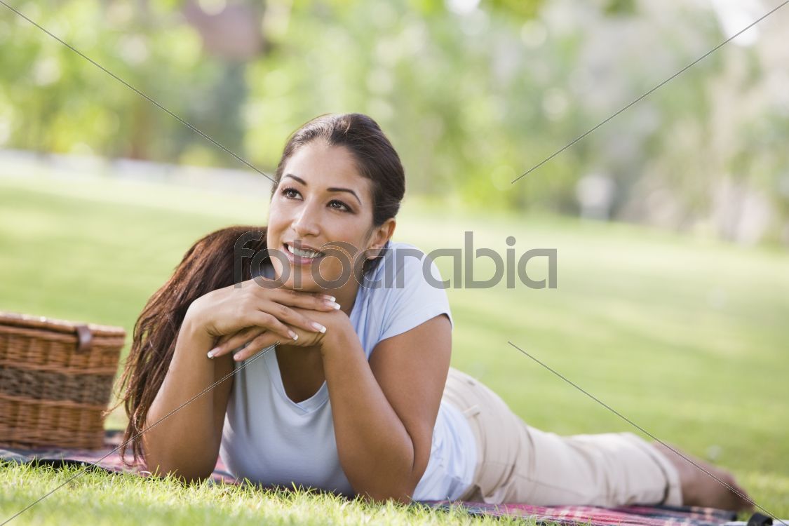 Woman relaxing in park with picnic