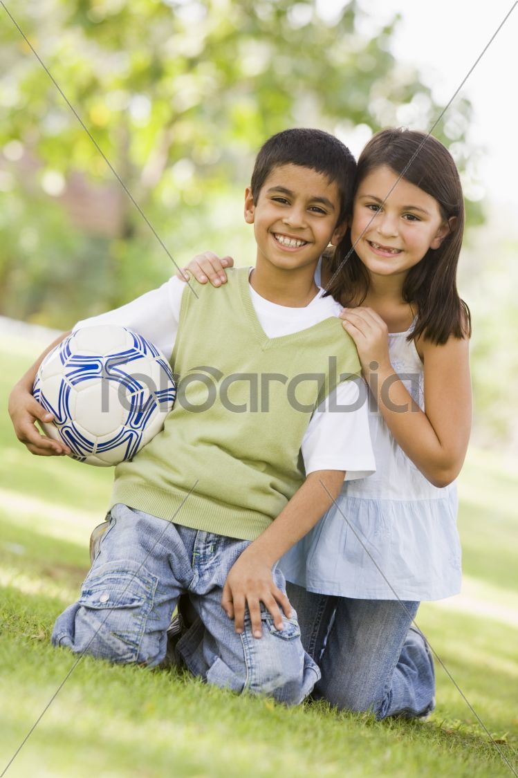 Two children playing football in park