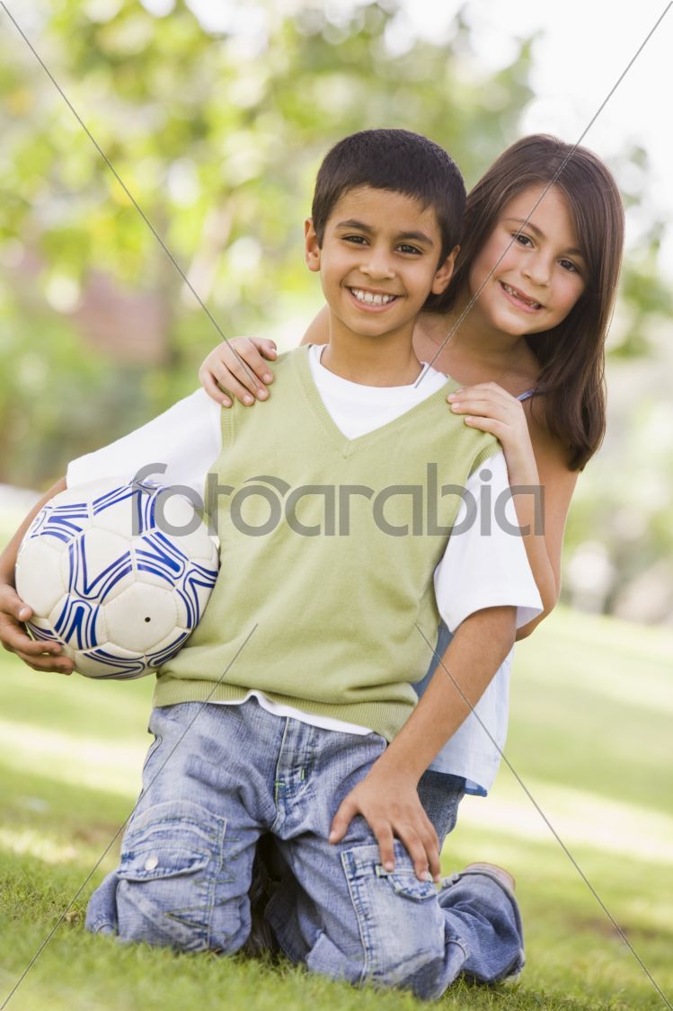 Children playing football in park
