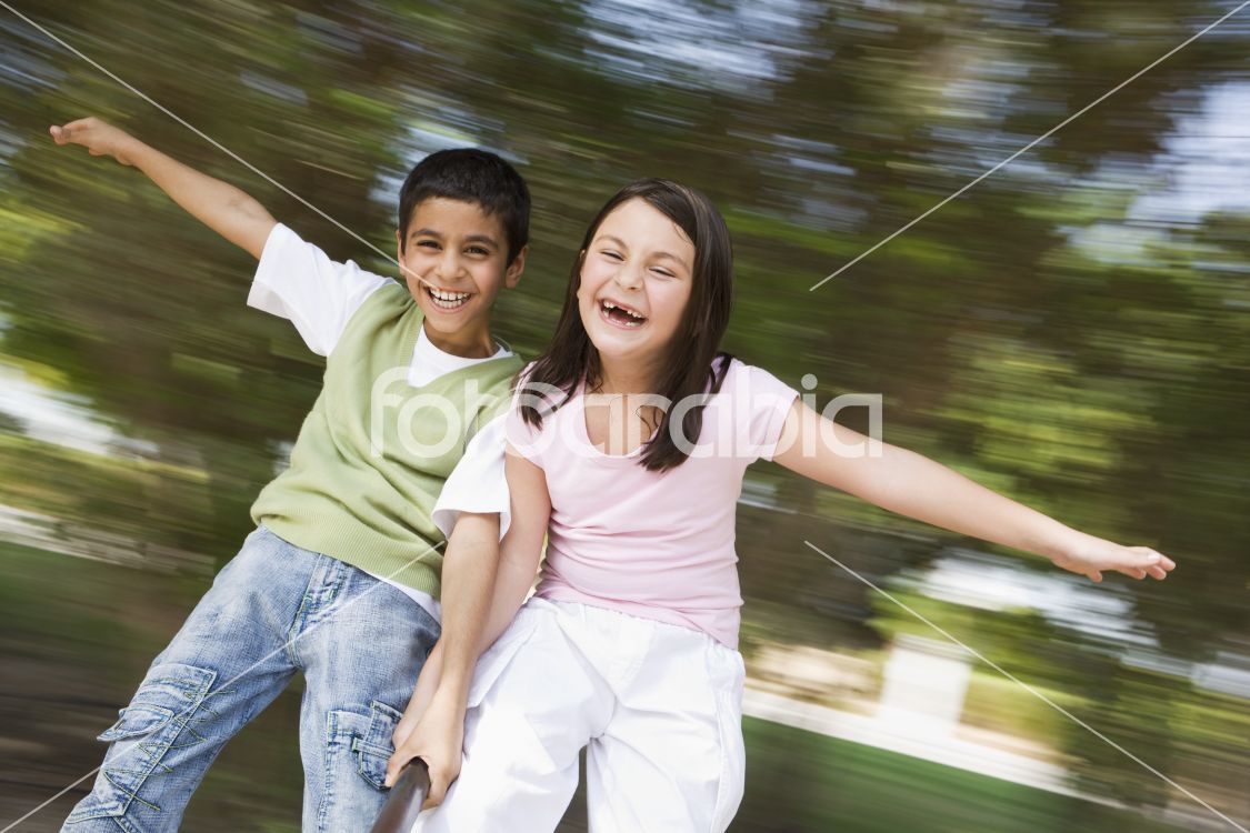 Two children having fun on roundabout