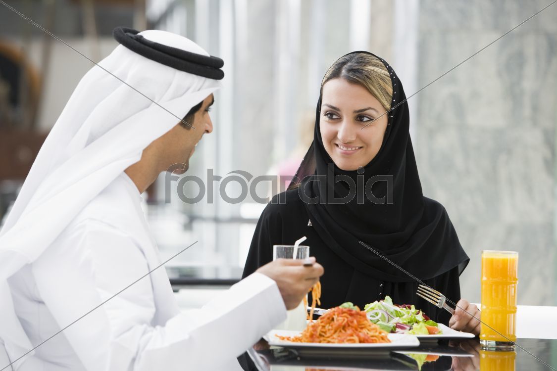 A Middle Eastern couple enjoying a meal in a restaurant