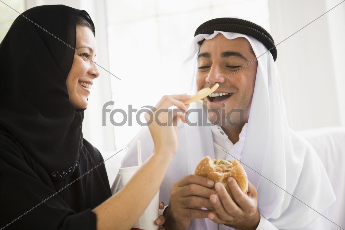 A Middle Eastern couple sharing a fast food meal