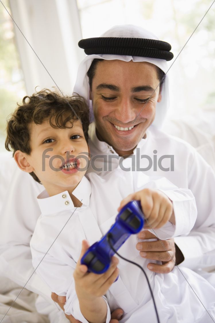 A Middle Eastern father and son playing a video game together